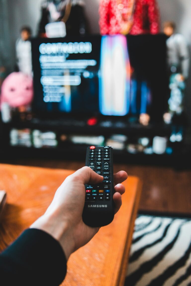 person holding a tv remote and pointing to a tv