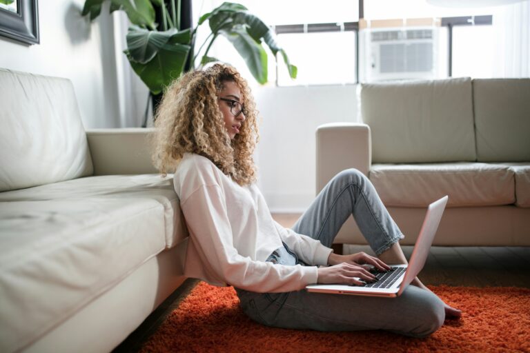 Woman sitting on the floor at home with her laptop