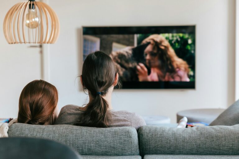 woman and girl watching tv in their living room