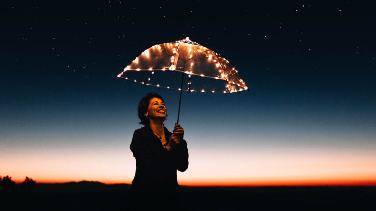 person holding an umbrella with lights in the evening