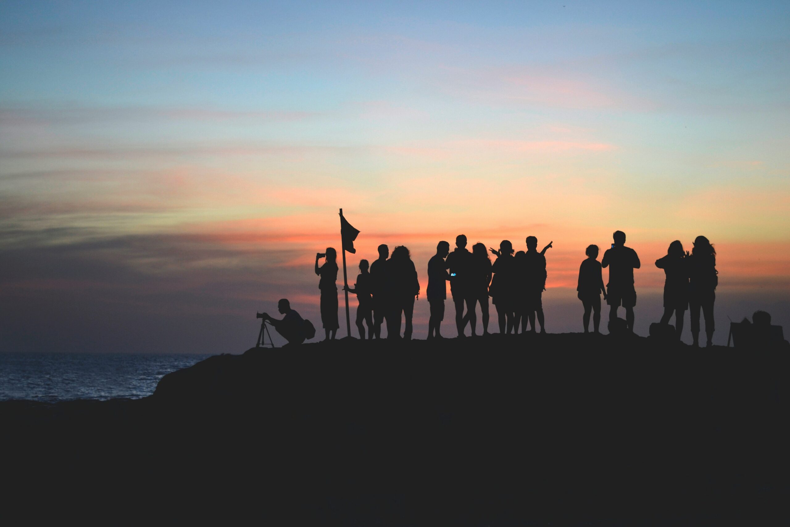 people on a mountain with an evening skyline