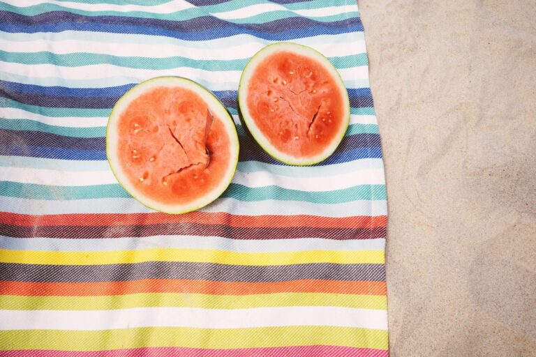two watermelons on a beach towel on a beach