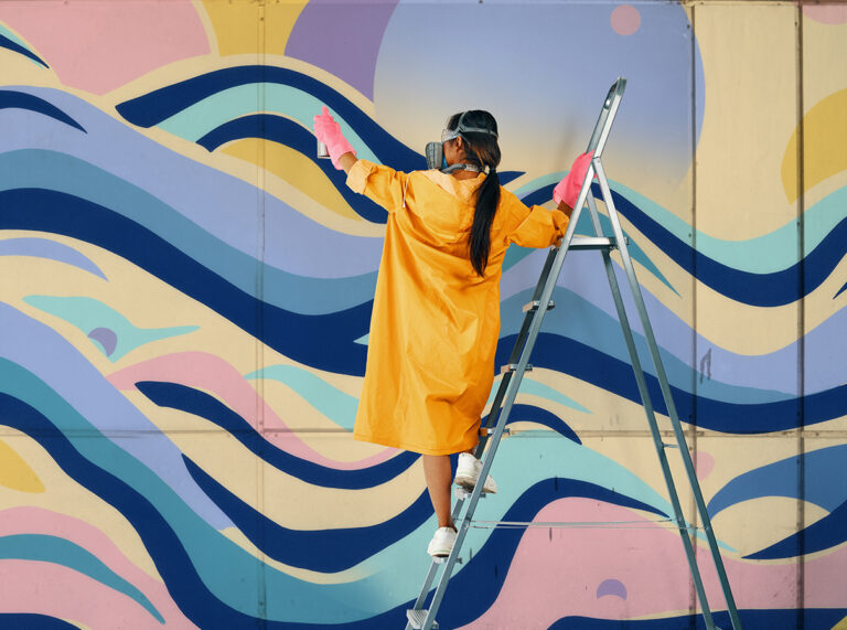 woman painting a colourful wall
