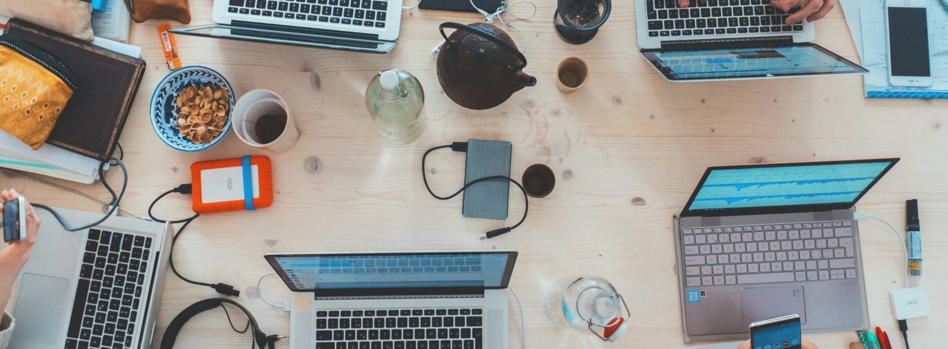 desk with laptops, coffee mugs