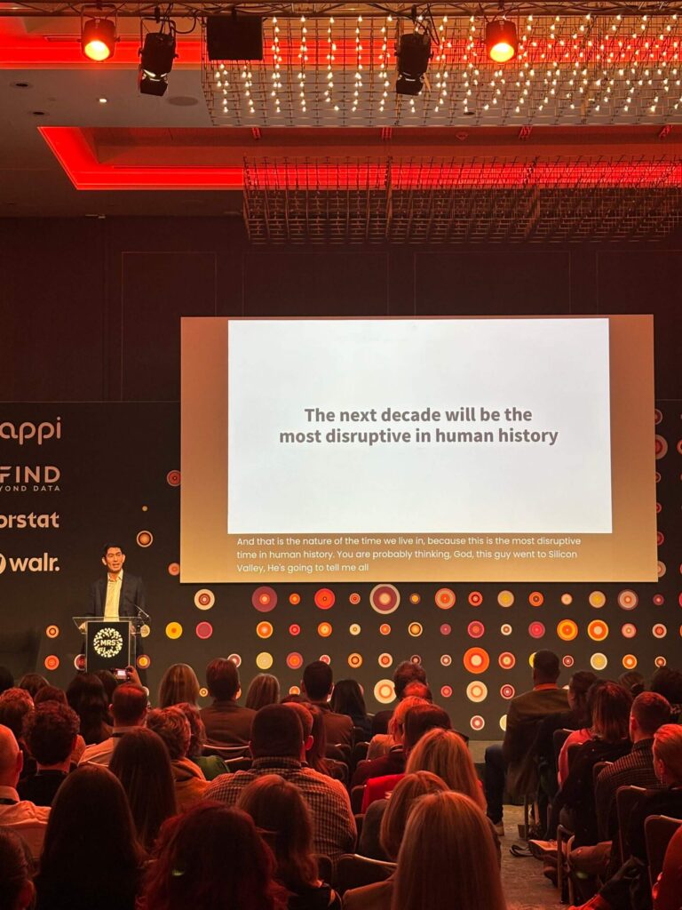 conference speaker and screen in a room full of people