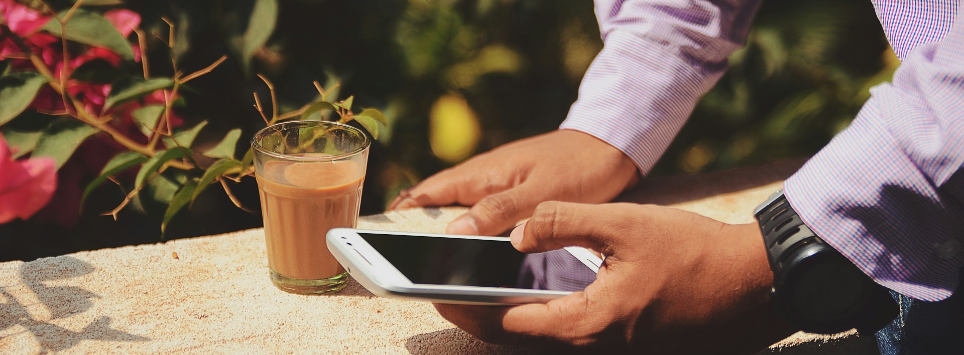 man holding a phone with a cup of coffee