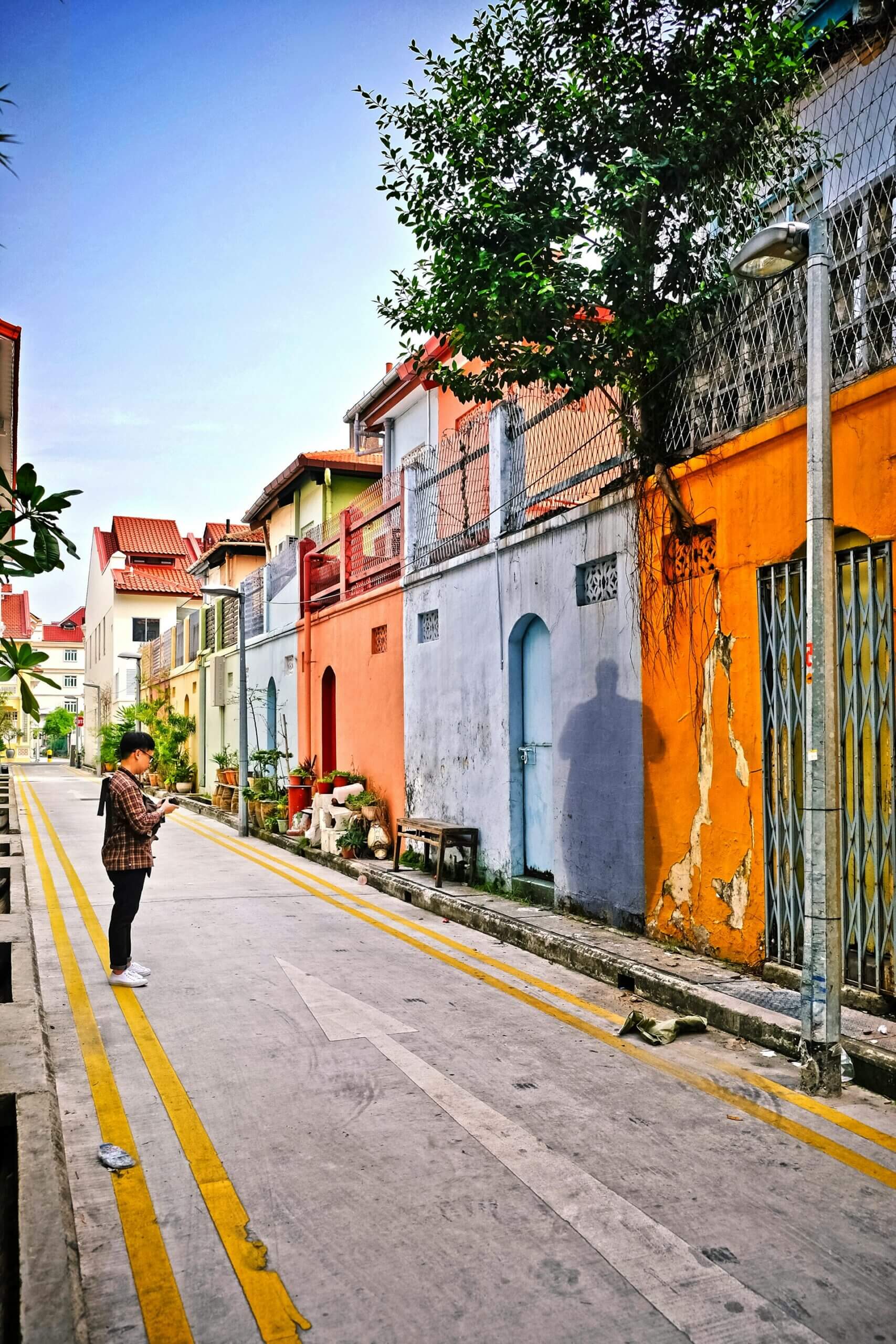 person standing on a street looking at colourful buildings