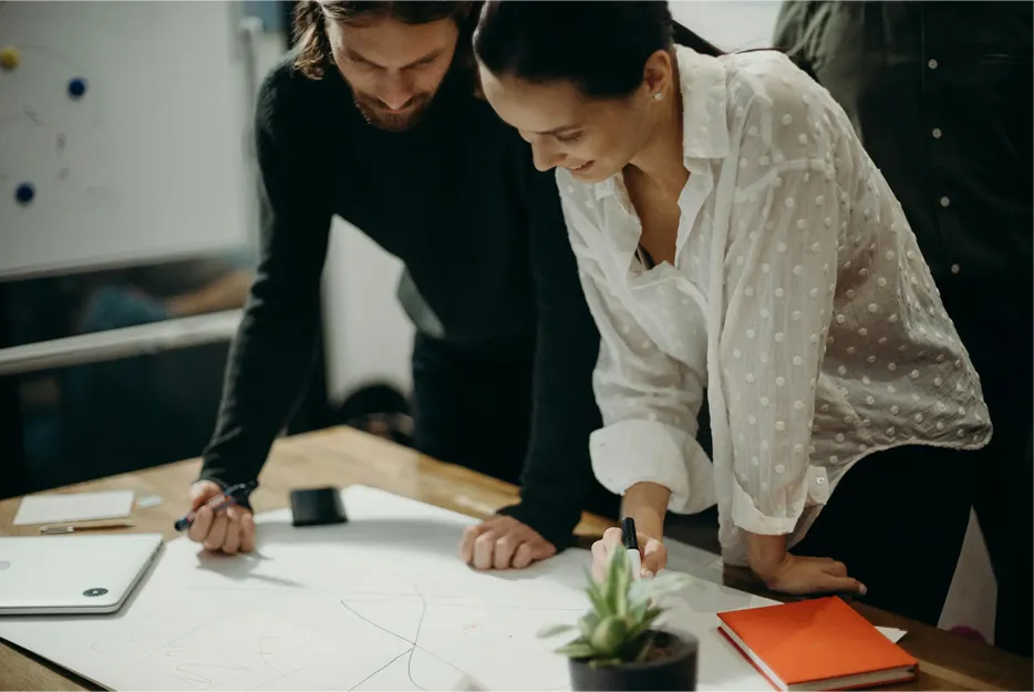 two people looking at work on a desk