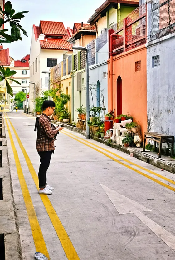 man standing on a street looking at his phone