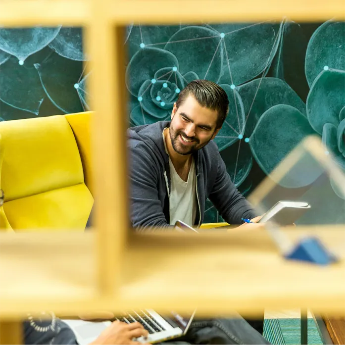 man smiling sitting on a yellow chair