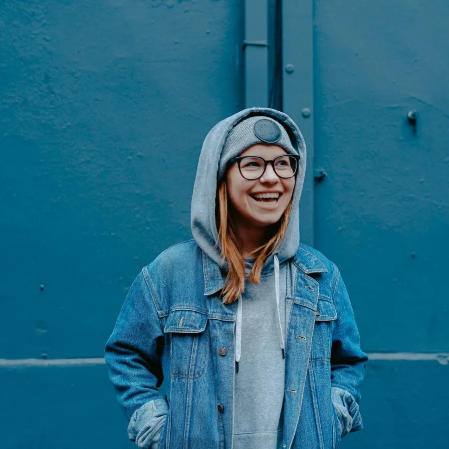 a woman standing in front of a blue wall