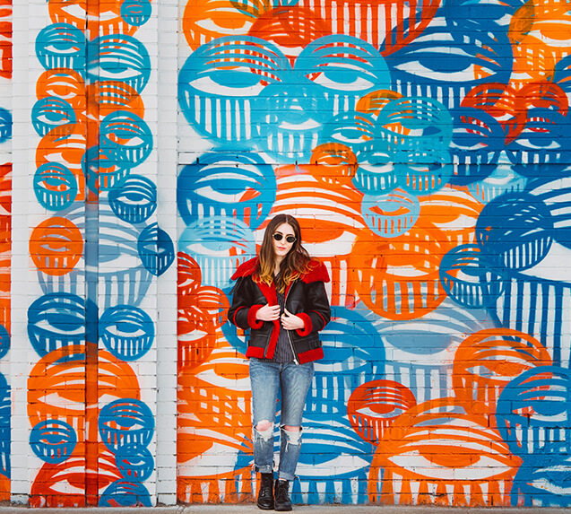 woman standing in front of a colourful blue and orange wall
