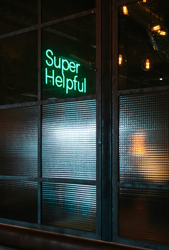 Sign Super Helpful in neon seen through the window