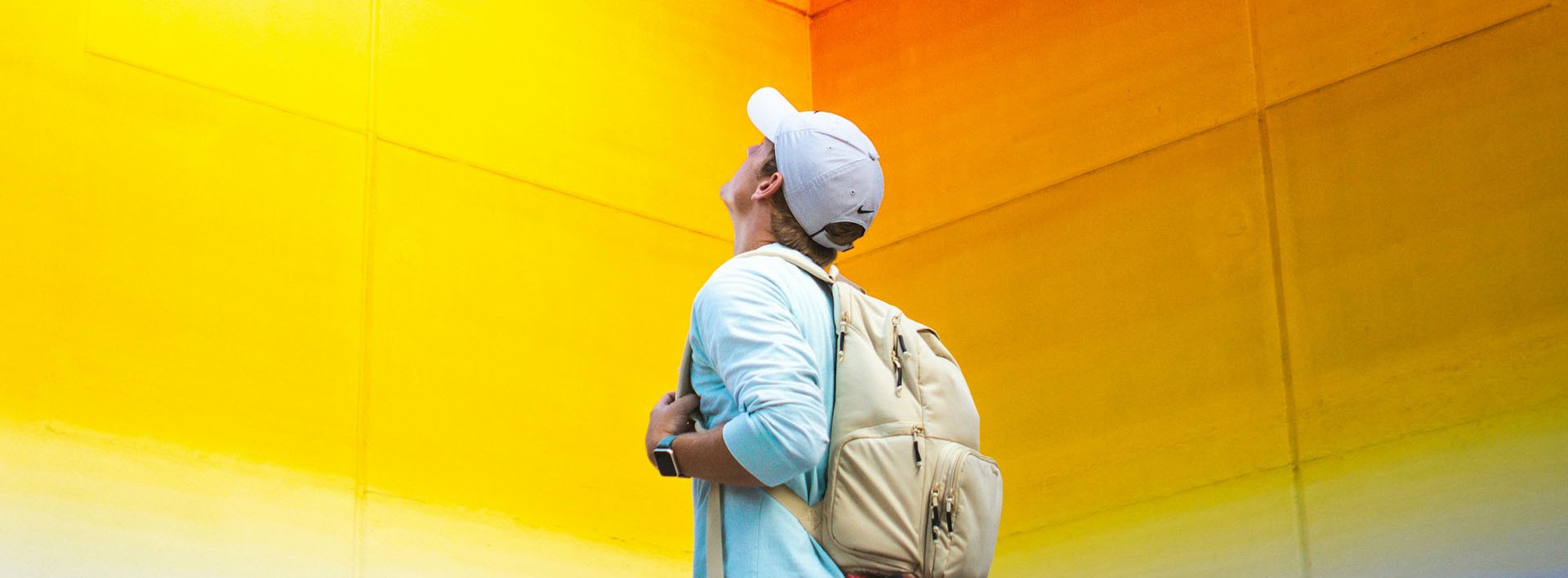 man looking up to a colourful wall
