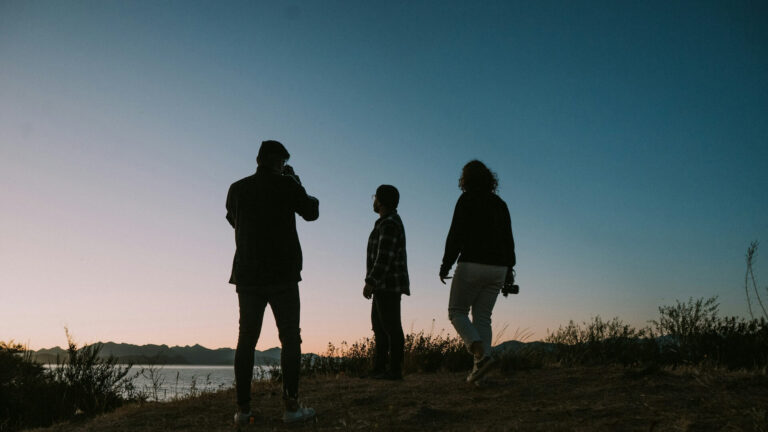 three people standing in nature