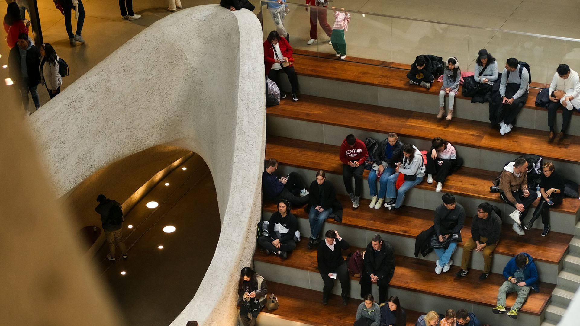 People sitting on modern wooden steps.