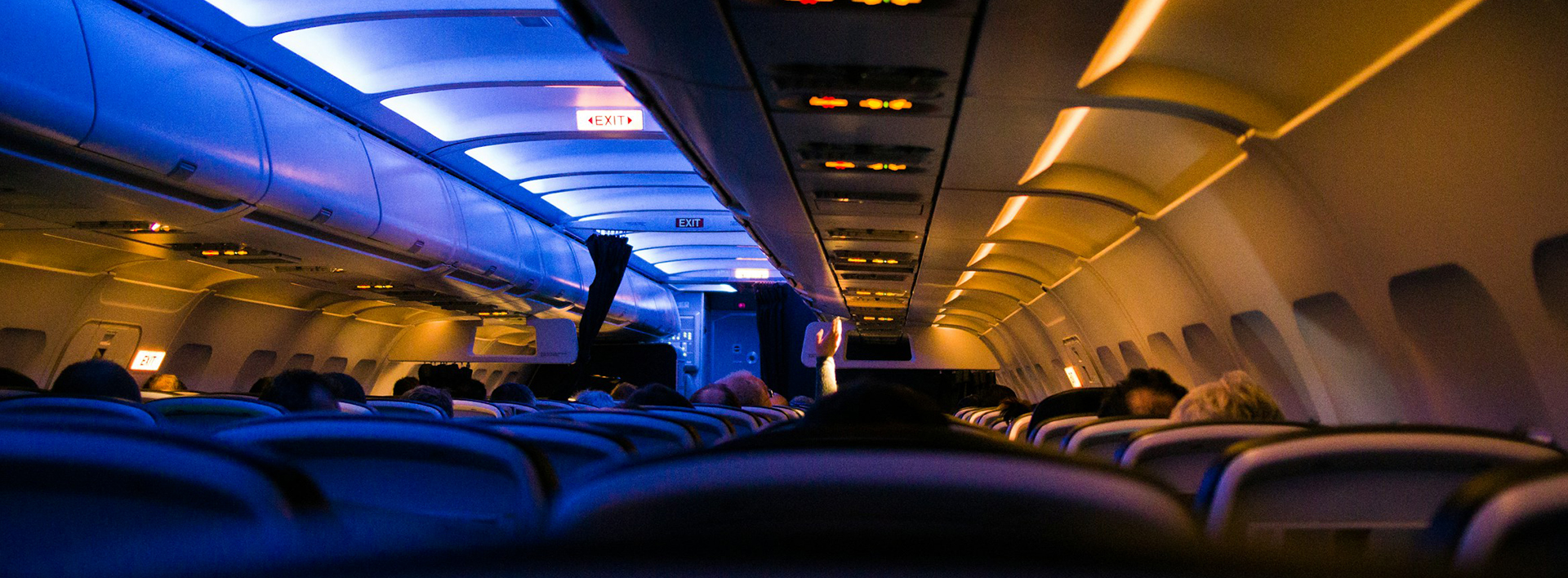 Interior view of an aeroplane with the cabin lights dimmed.