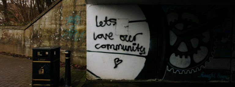 Graffiti on wall reads 'let's love our community'