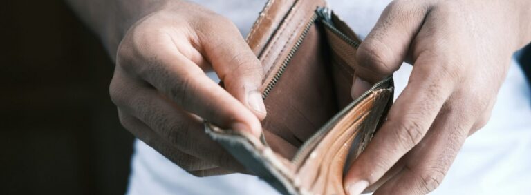 Close up of a man holding an open wallet which is empty