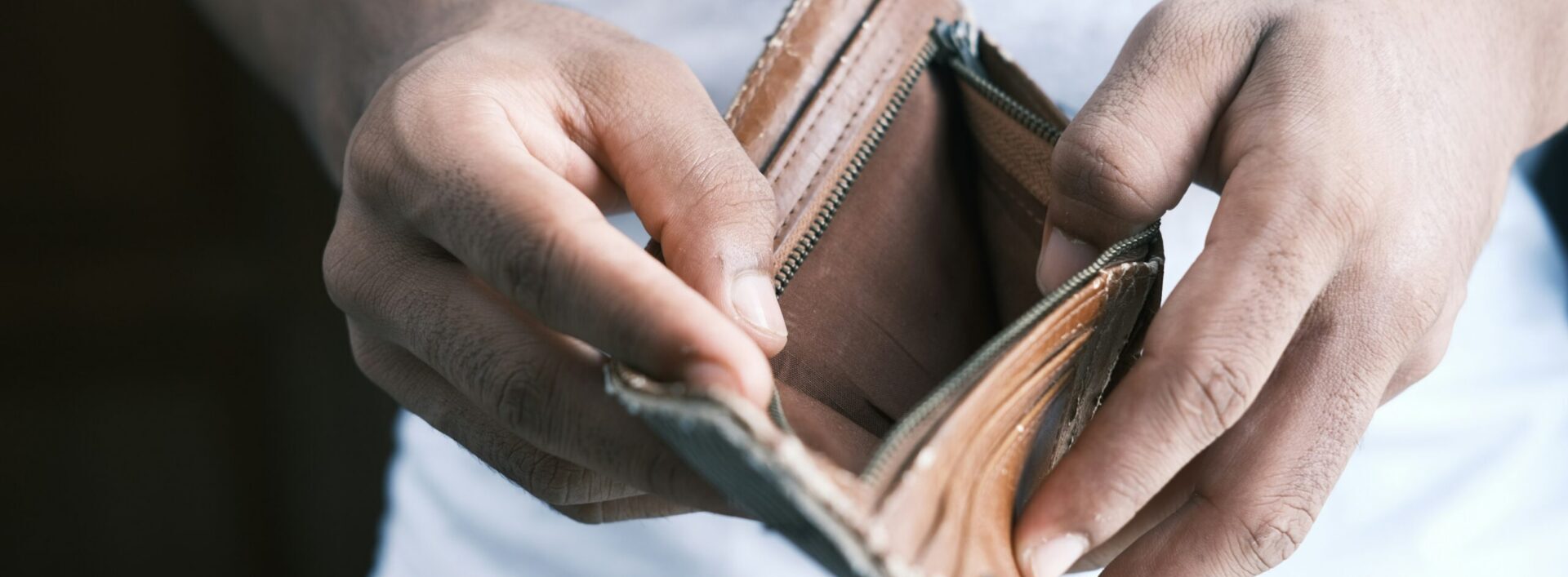 Close up of a man holding an open wallet which is empty