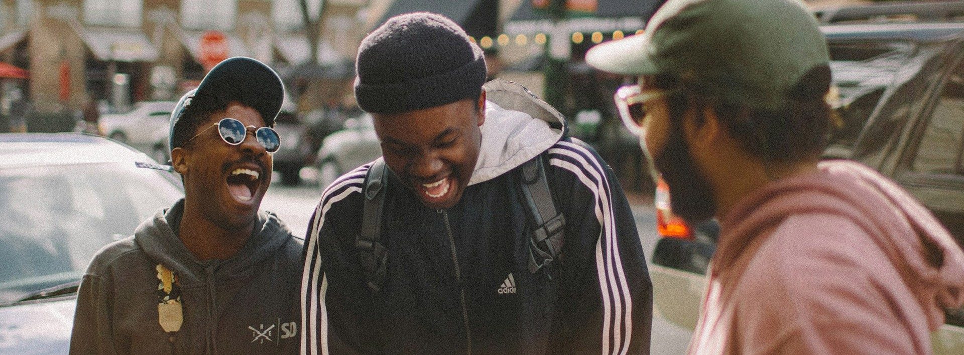 Three individuals conversing on the street.